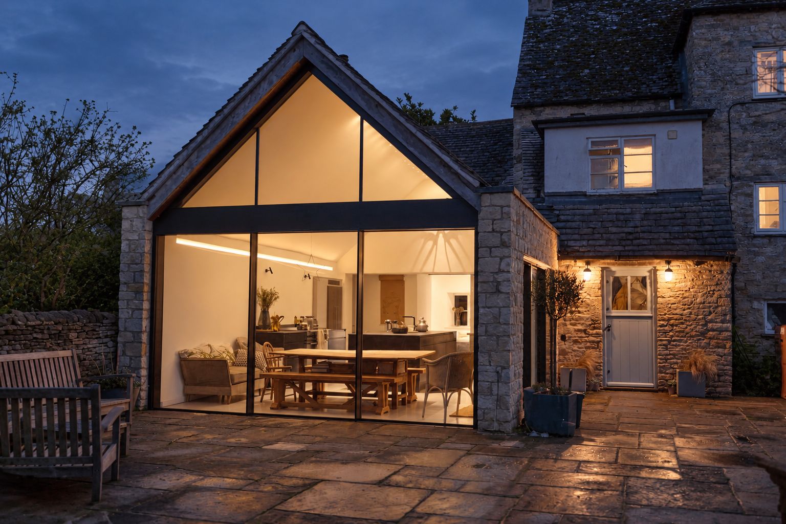 Illustrative home with a glazed extension and warmly lit living space at dusk